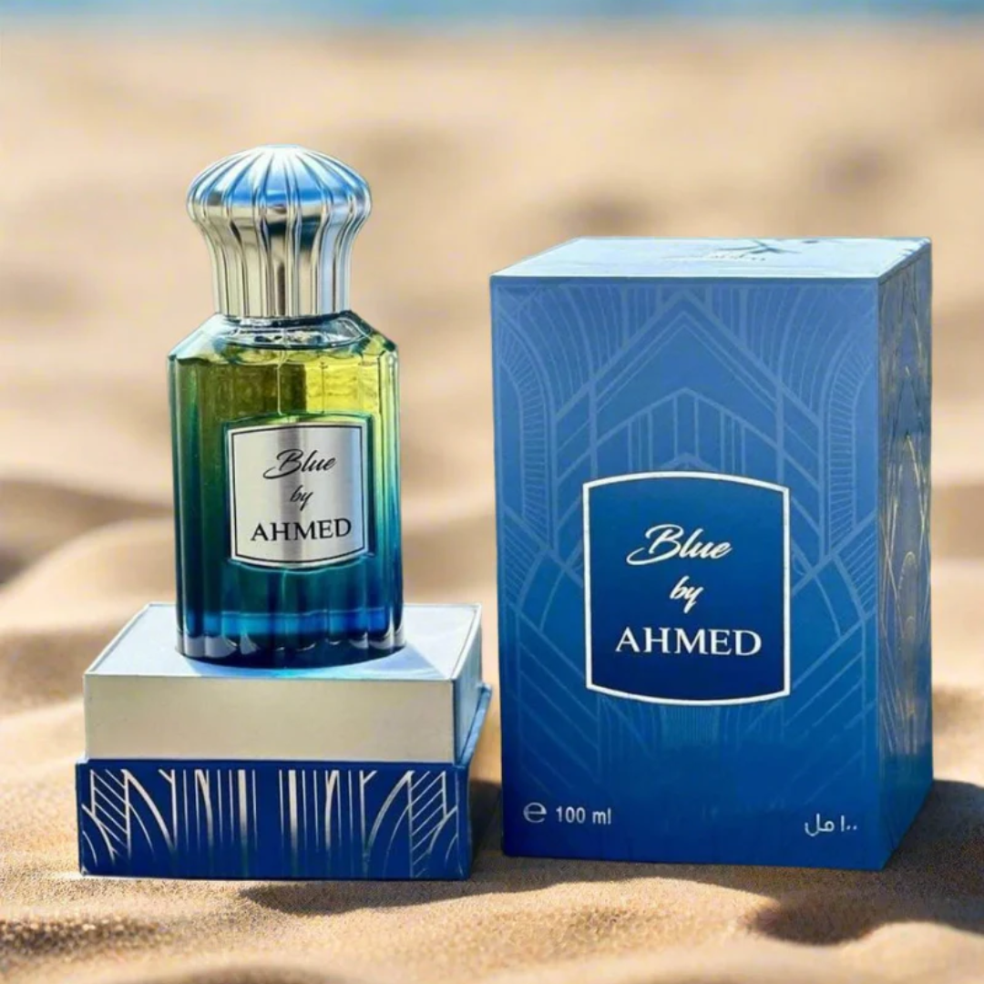 Perfume bottle and packaging of 'Blue by Ahmed' on a sandy background