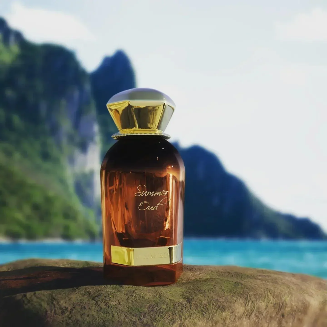 Amber perfume bottle with gold cap on a rock by a scenic ocean view. Ahmed Al Maghribi Summer Oud Unisex Perfume