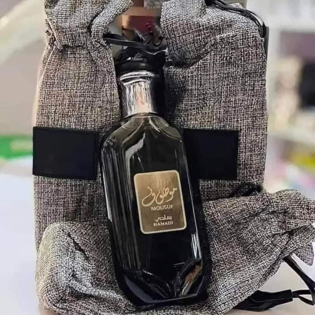 Mousuf Ramadi Eau de Parfum black edition – opulent Arabian fragrance in a sleek black glass bottle with silver cap, placed alongside an elegant grey drawstring pouch. Clone / dupe of / inspired by Jean Paul Gaultier - Ultra Male perfume.