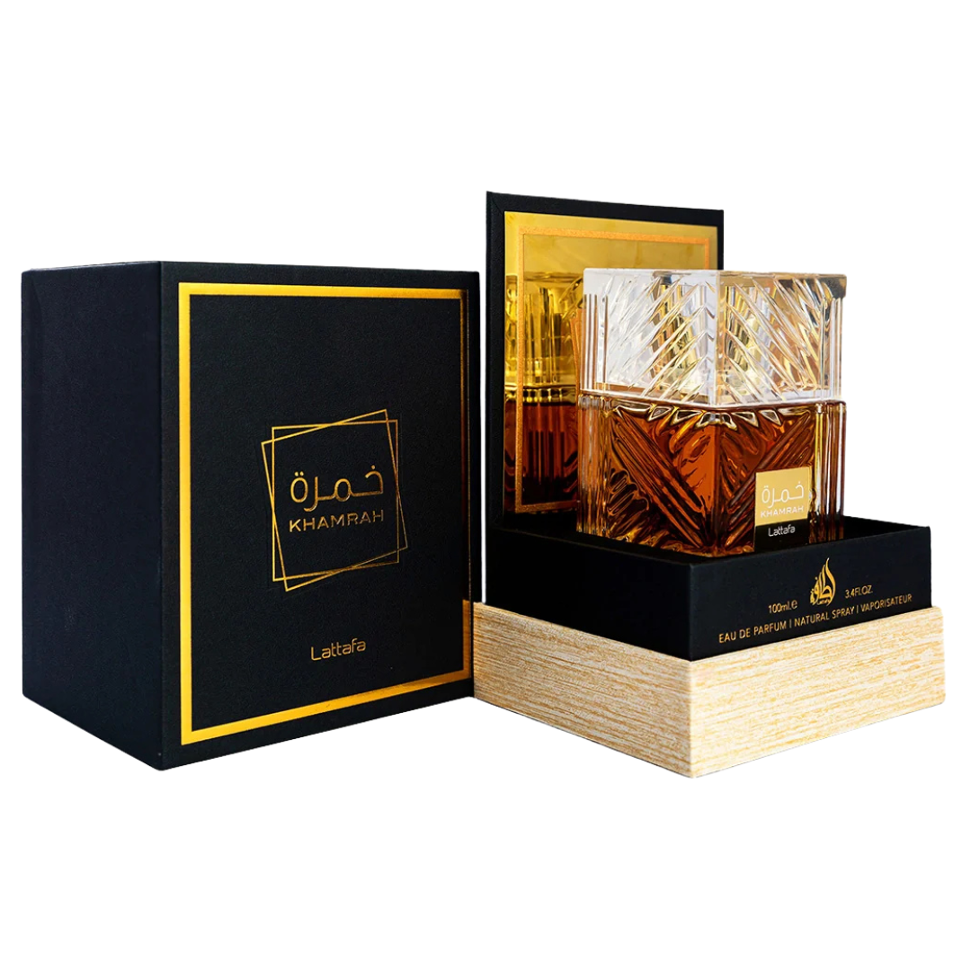 A luxurious crystal bottle of Khamrah unisex Eau de Parfum by Lattafa, displaying the amber-colored perfume liquid. Clone / dupe of / inspired by Killian - Angels' Share unisex fragrance. Unboxing Lattafa Khamrah Perfume – Sophisticated unboxing view showcasing the amber-hued fragrance in a luxury clear glass bottle inside a black and gold gift box.