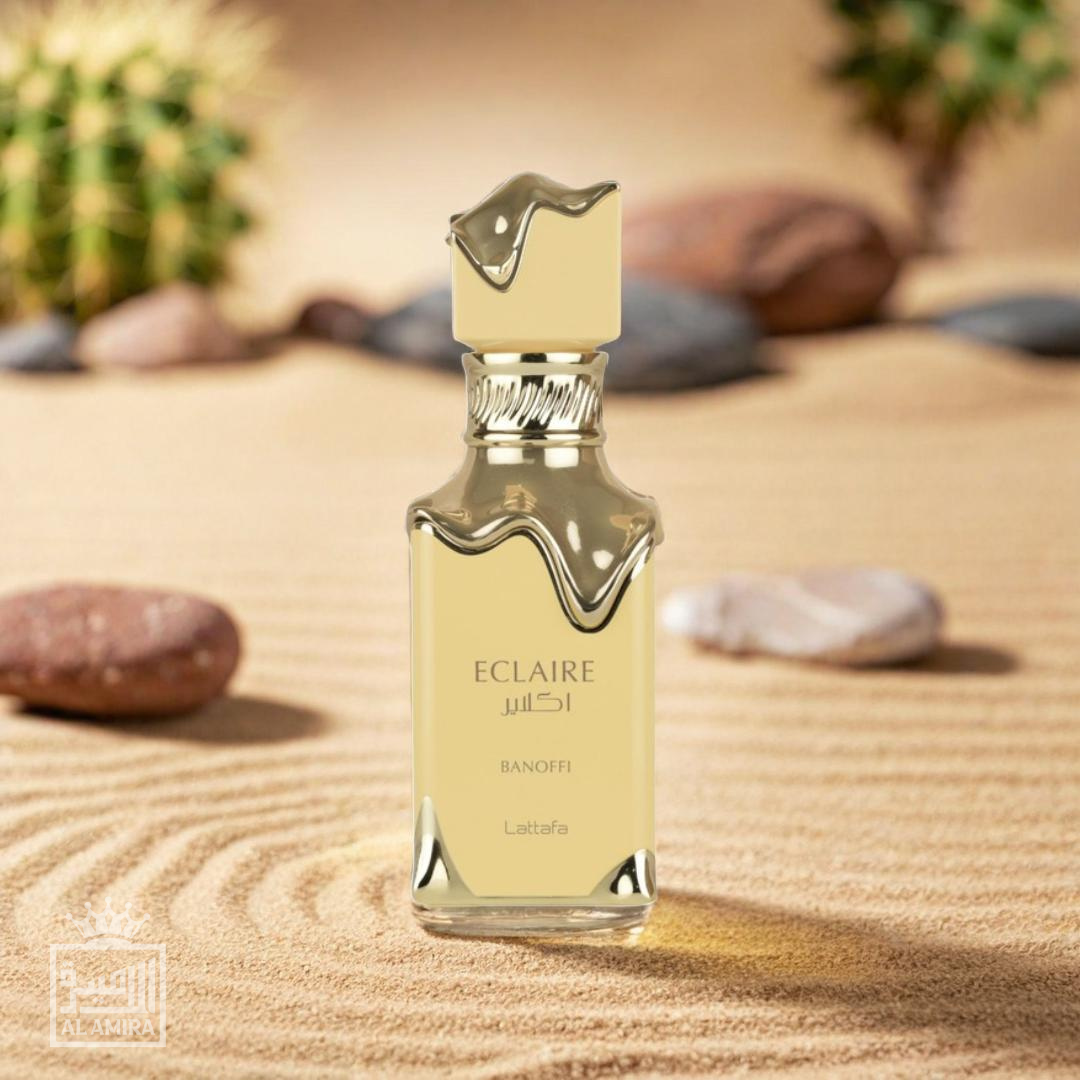 Eclaire Banoffi perfume bottle on a sandy surface with rocks and plants in the background