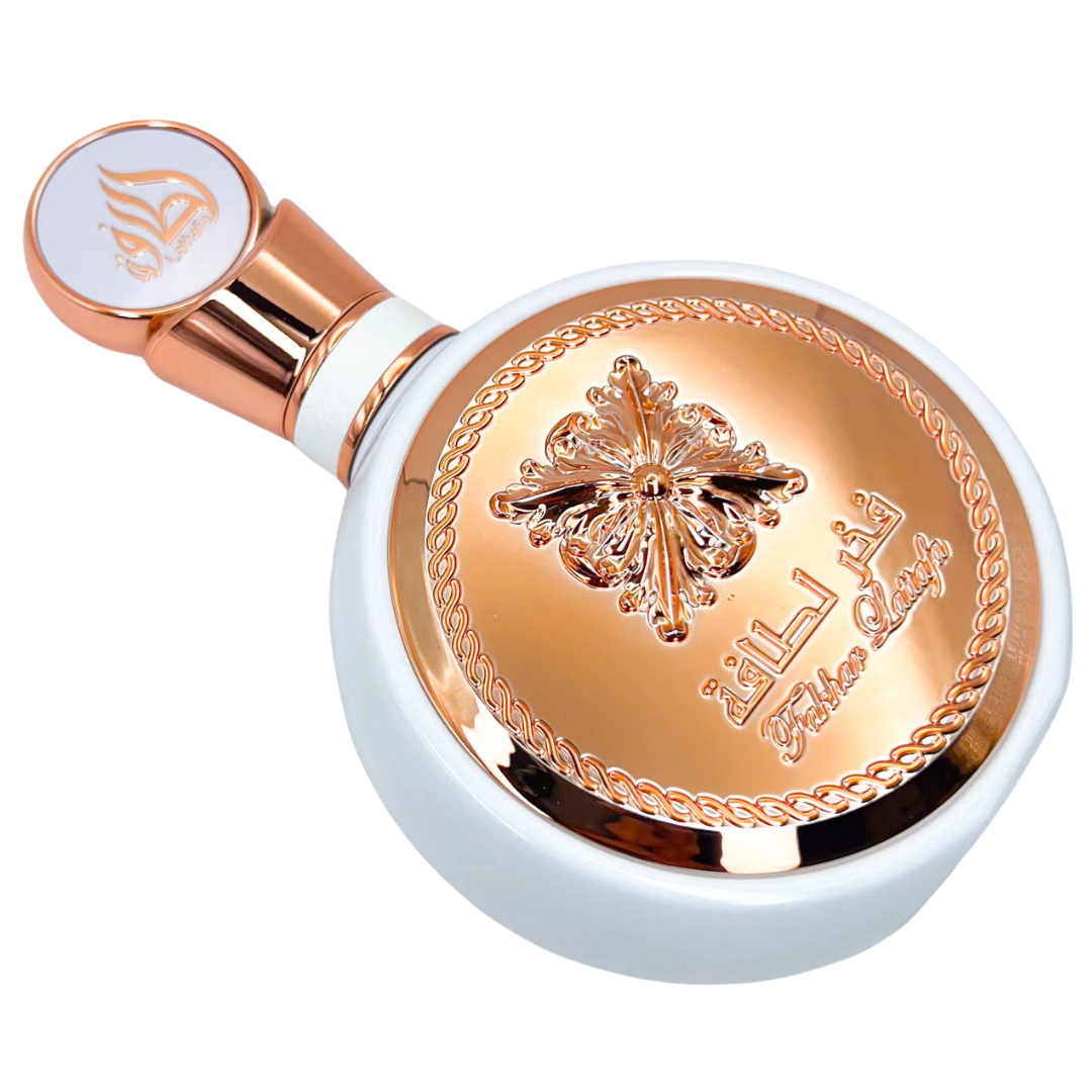 Lattafa Fakhar Eau de Parfum bottle in a horizontal position, highlighting the detailed rose-gold medallion design and premium craftsmanship. Clone / dupe of / inspired by Givenchy - L’Interdit perfume.