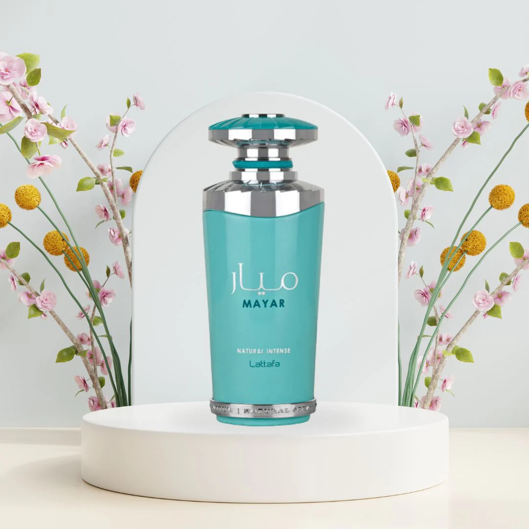 Blue cosmetic bottle on a white pedestal with flowers in the background. Lattafa Mayar Natural Intense Womens Perfume