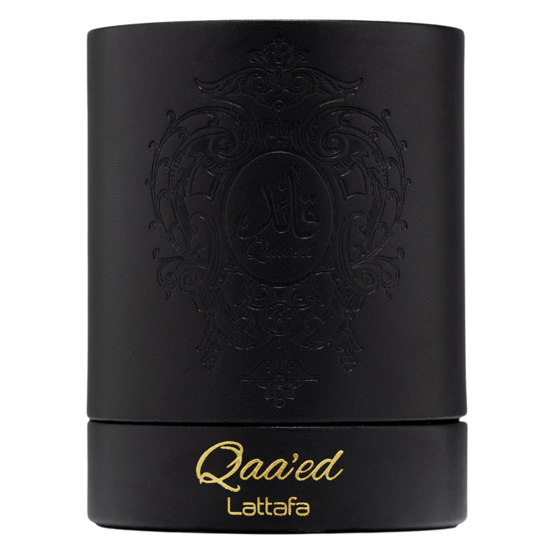 Elegant black cylindrical Lattafa Qaa’ed perfume box with gold embossed lettering and intricate Arabic design, representing high-end Arabian perfumery. Clone / dupe of / inspired by Dolce & Gabbana - Velvet Desert Oud perfume.