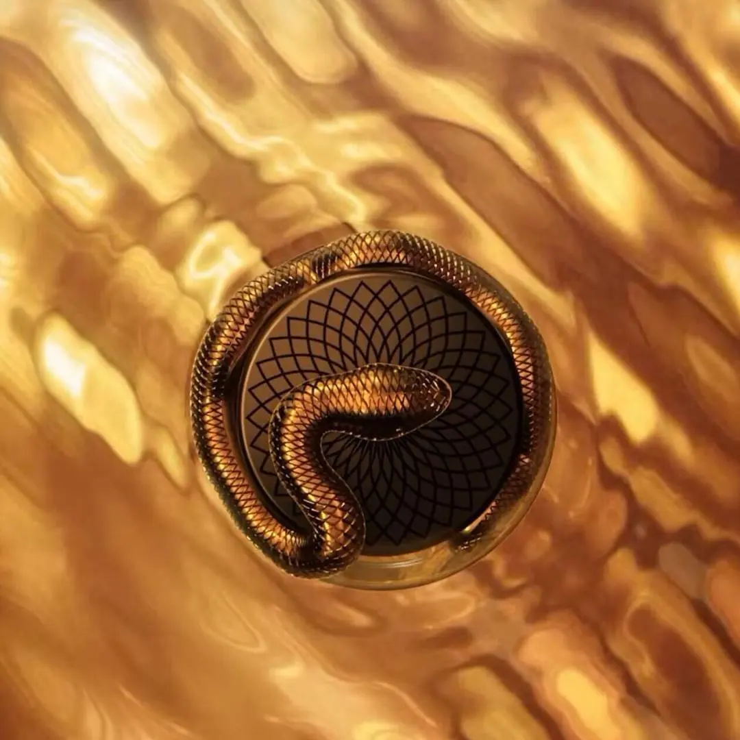 Decorative button with snake design on a gold background. Lattafa Teriaq Intense Unisex Perfume