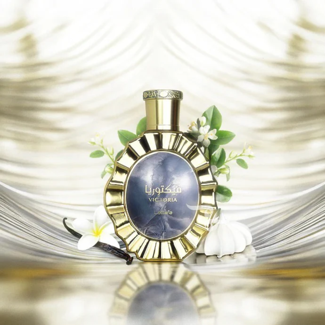 Perfume bottle with gold cap and decorative elements on a reflective surface. Lattafa Victoria Unisex Perfume.