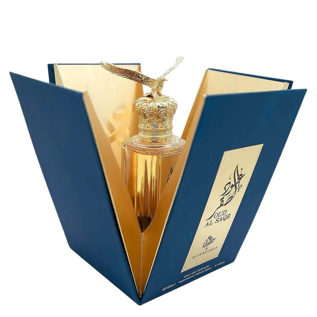 Gold perfume bottle in a blue triangular box on a white background. Oud Al Saqr by Arabiyat Prestige Unisex Perfume