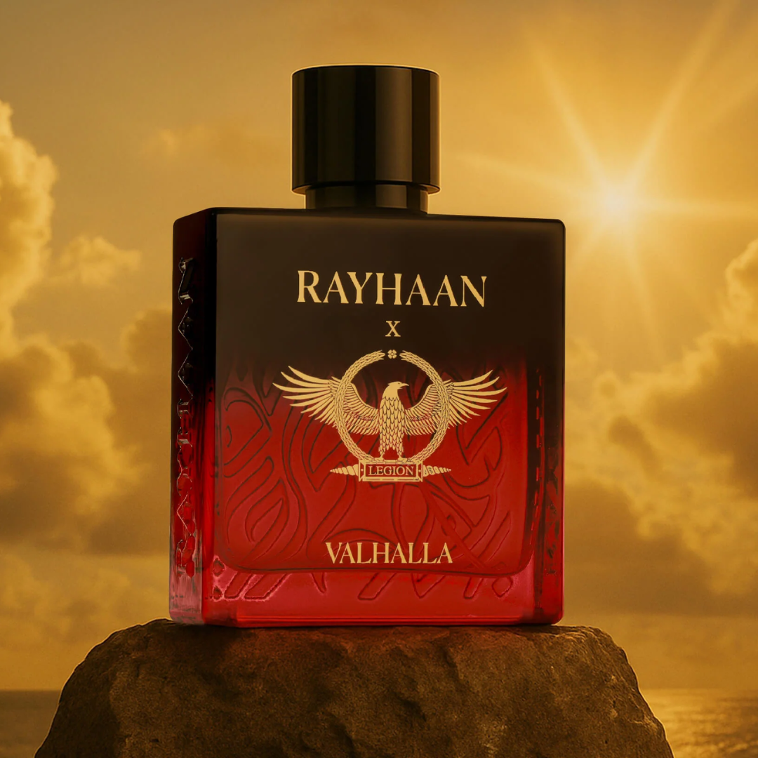 Red and black perfume bottle labeled 'RAYHAAN X VALHALLA' against a sunset sky. Rayhaan X Valhalla Mens Perfume