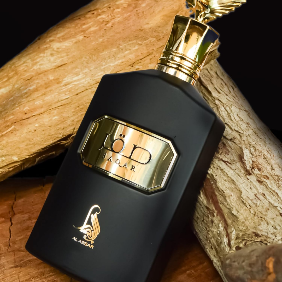 Black perfume bottle with gold cap on a wooden surface