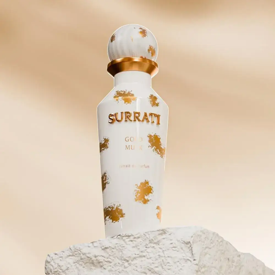 Surrati perfume bottle with gold accents on a beige background