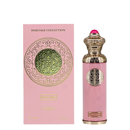 Pink perfume bottle with gold cap and intricate design next to its packaging on a white background. Surrati Pink Miss Womens Perfume