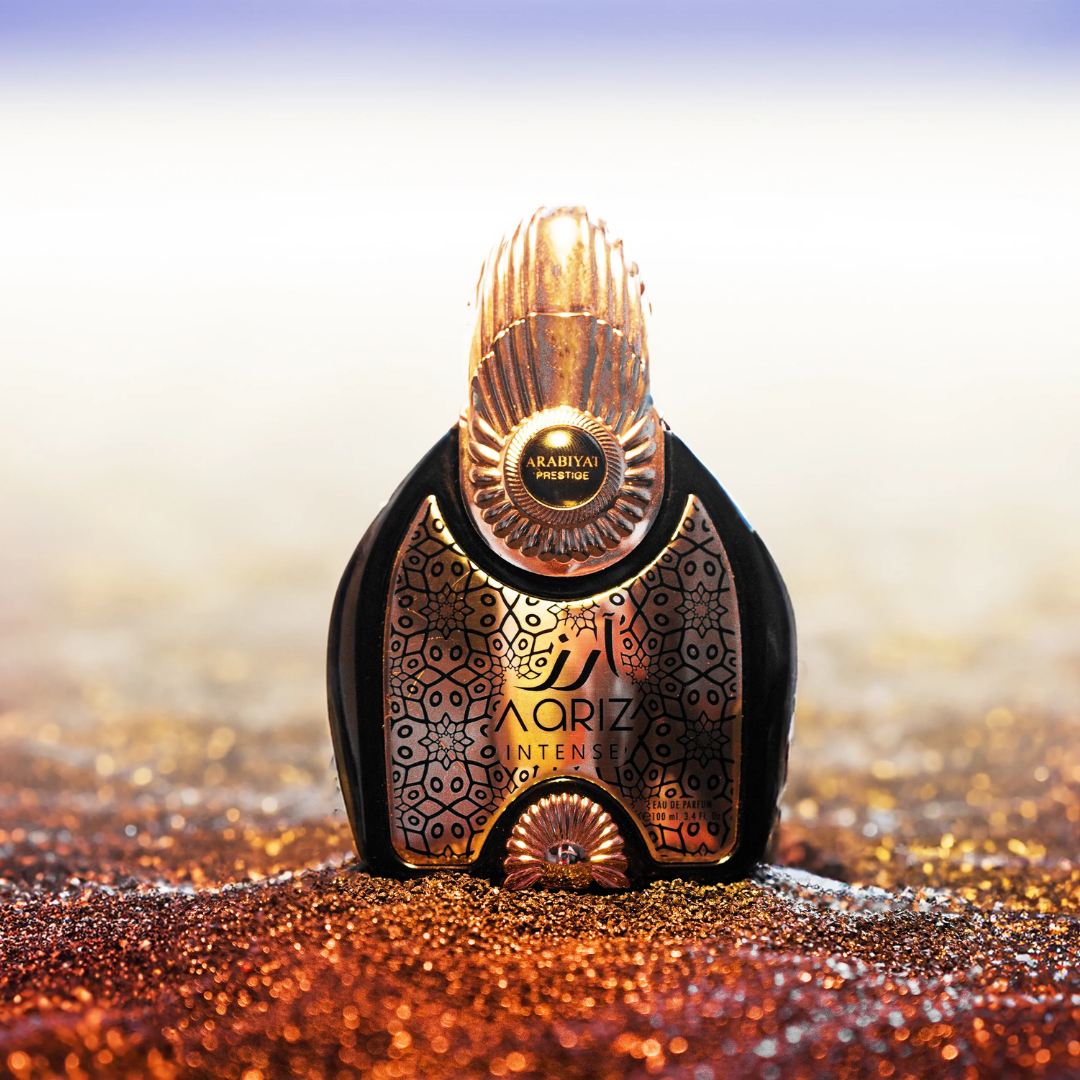 Decorative perfume bottle on a glittery surface with a blurred background. Aariz Intense by Arabiyat Prestige Unisex Perfume