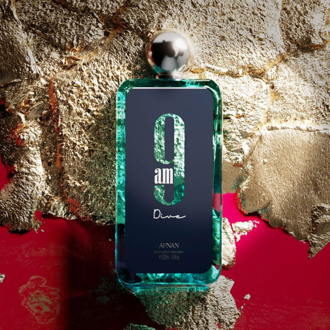 Blue perfume bottle with '9 am Dive' text on a textured gold and red background