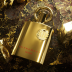 Gold bottle of Supremacy Gold by Afnan perfume on a textured dark surface