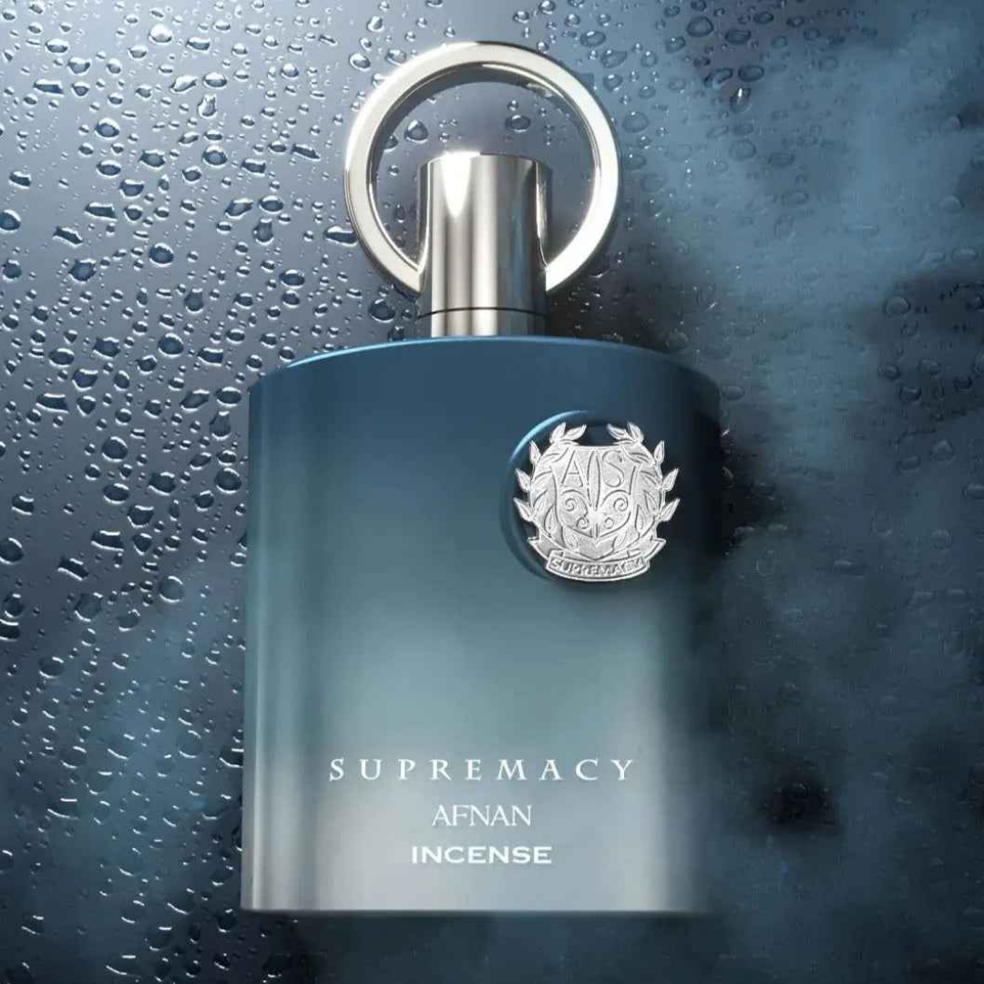 Blue perfume bottle with silver cap on a wet surface. Afnan: Supremacy Incense