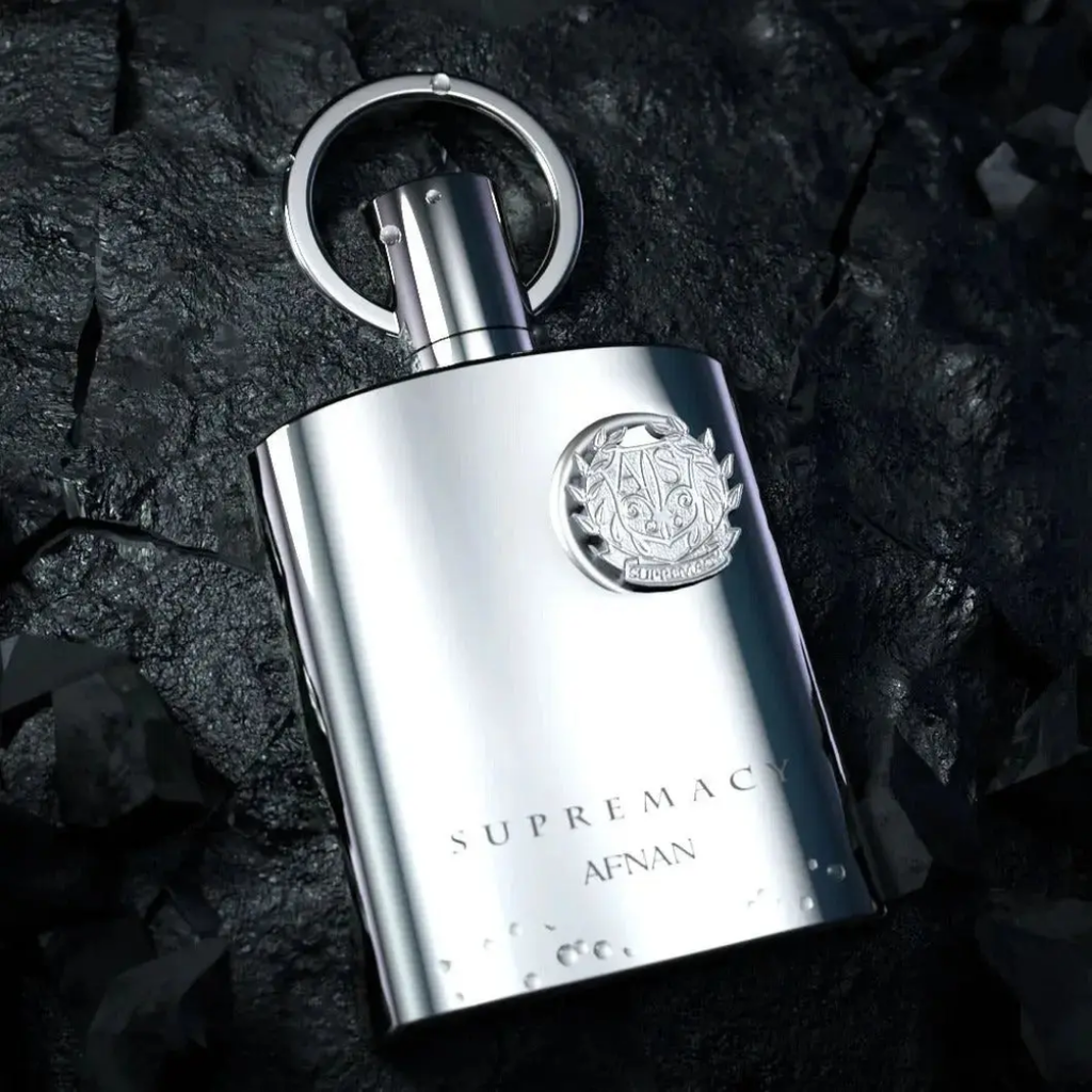 Afnan: Supremacy Silver bottle with a logo on a dark stone surface