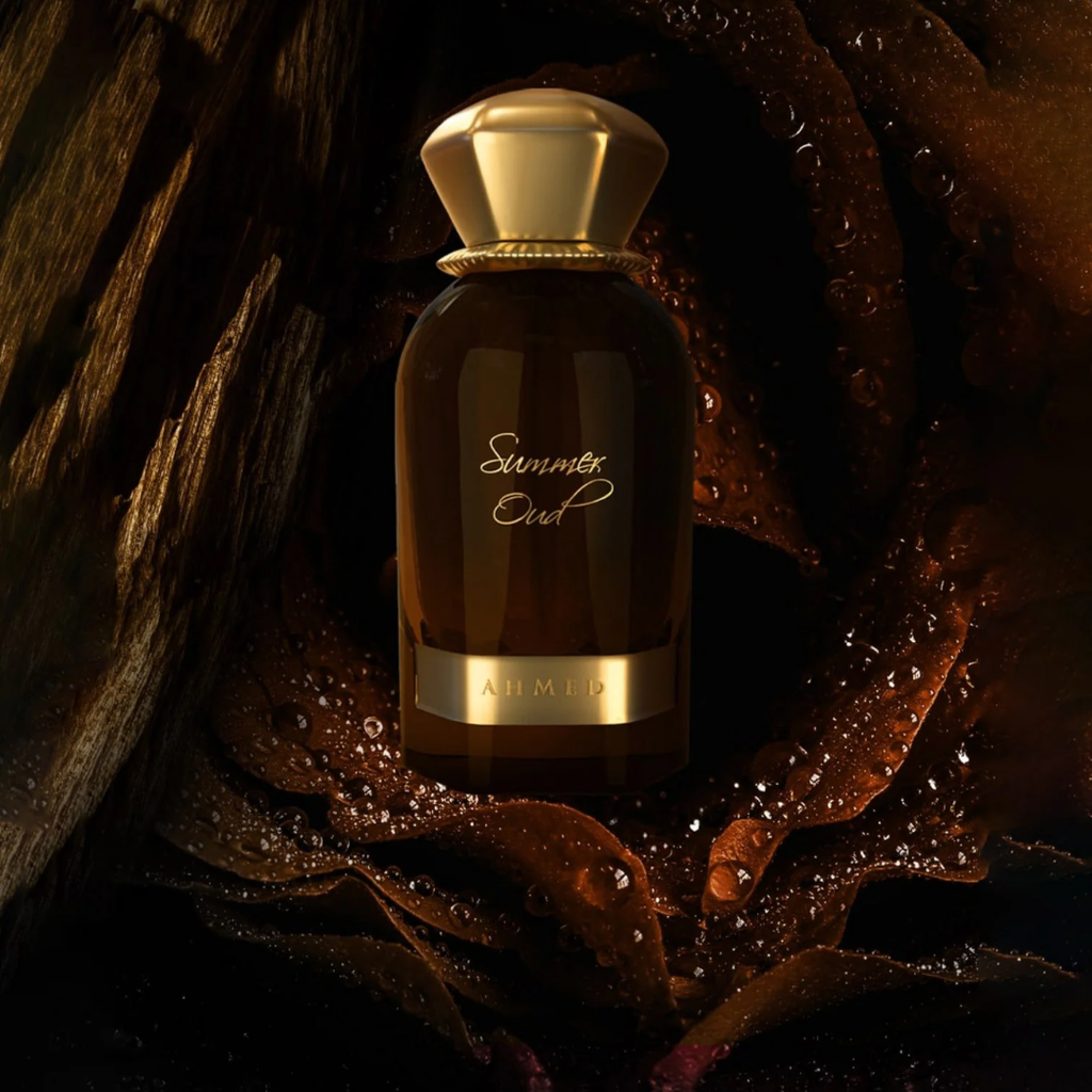 Perfume bottle labeled 'Summert Oud' by Alhambra on a dark leafy background
