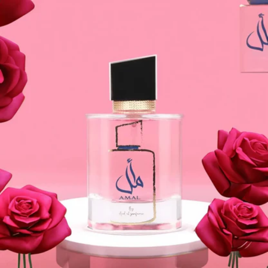 Perfume bottle with 'AMAL' branding surrounded by pink roses on a pink background