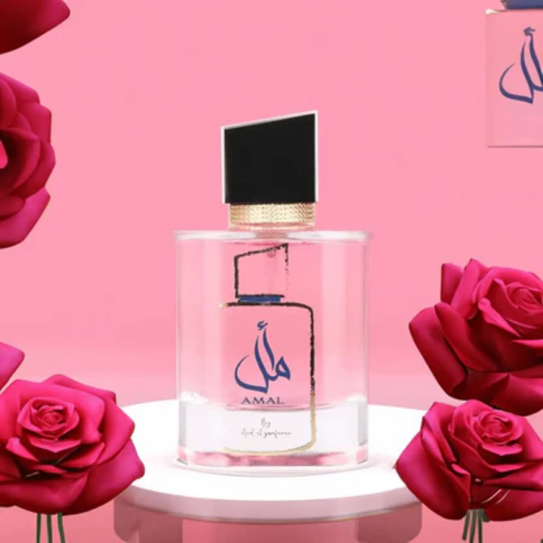 Perfume bottle with 'AMAL' branding surrounded by pink roses on a pink background