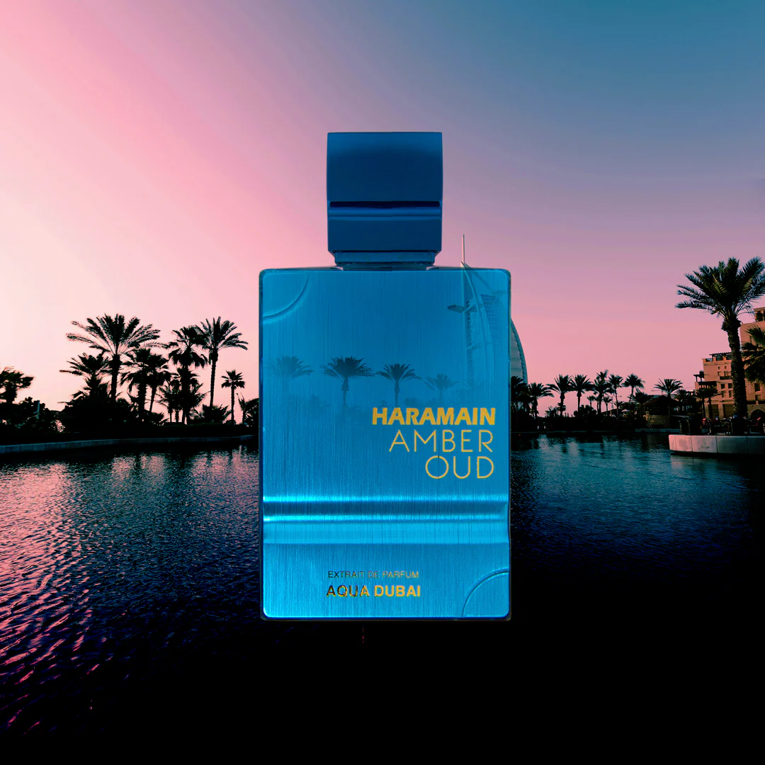 Haramain Amber Oud perfume bottle with palm trees and sunset in the background. Amber Oud Aqua Dubai by Al Haramain Unisex Perfume
