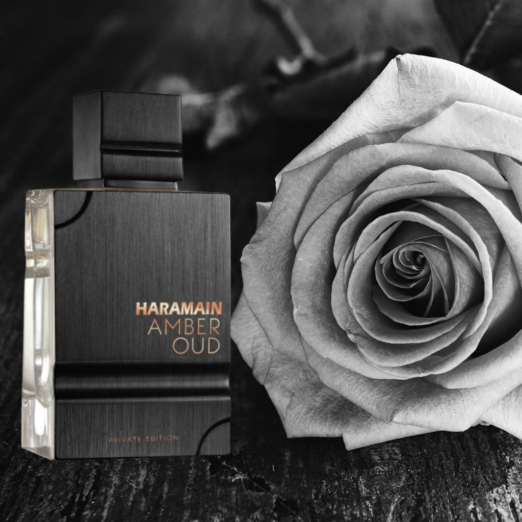 Haramain Amber Oud perfume bottle with a rose on a dark background. Amber Oud Private Edition by Al Haramain Unisex Perfume