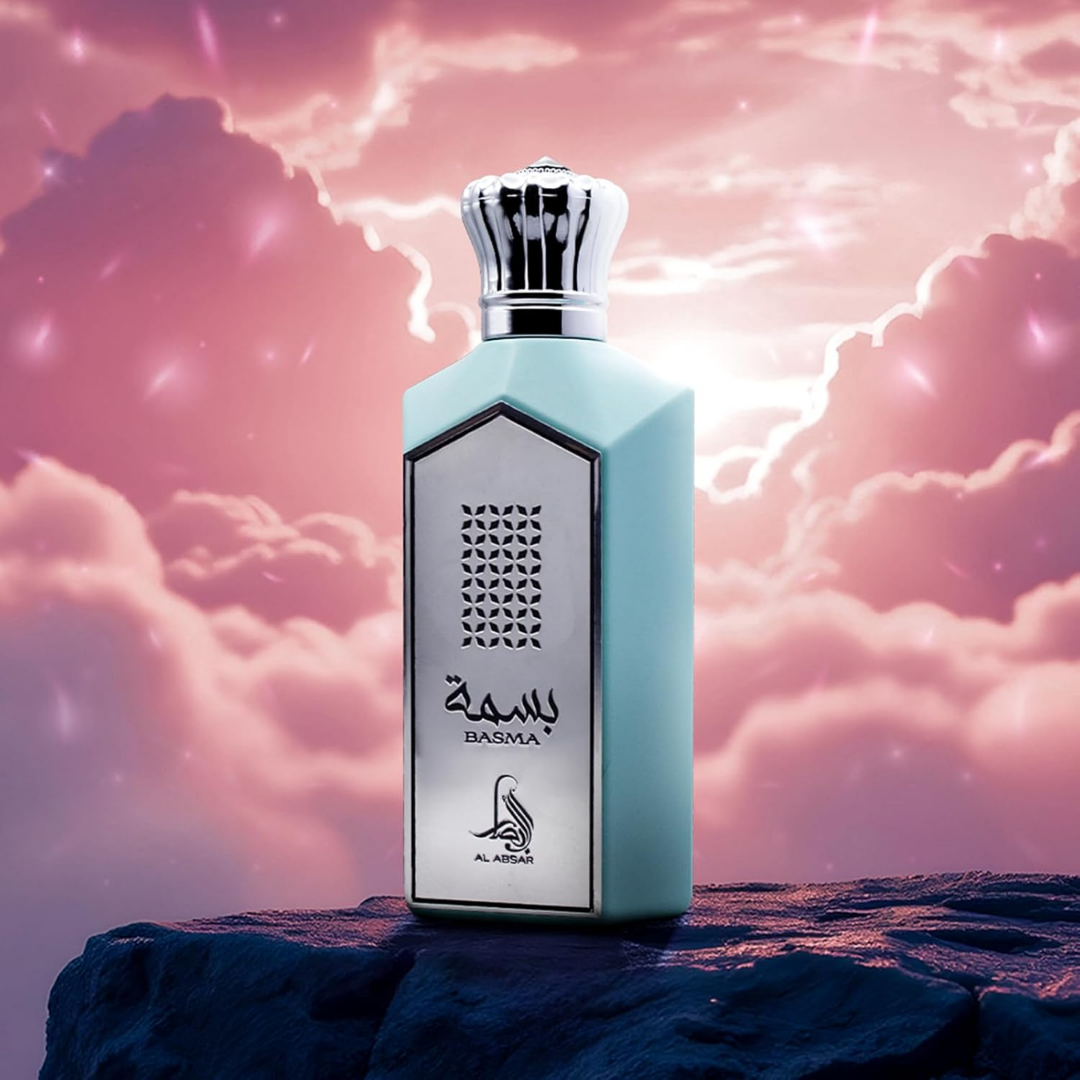 Perfume bottle with 'Basma' branding against a pink sky with clouds