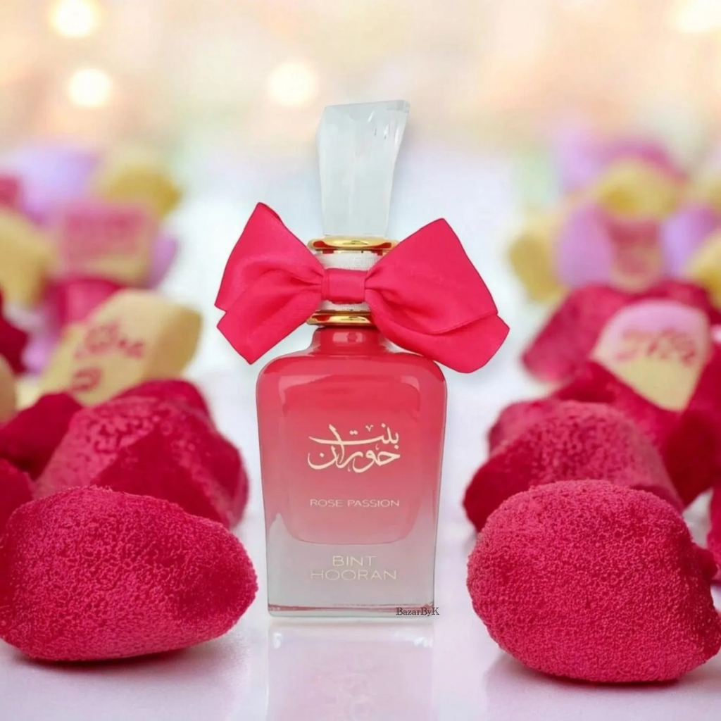 Perfume bottle with a pink bow surrounded by pink hearts on a blurred background. Bint Hooran Rose Passion Womens Perfume by Ard Al Zaafaran