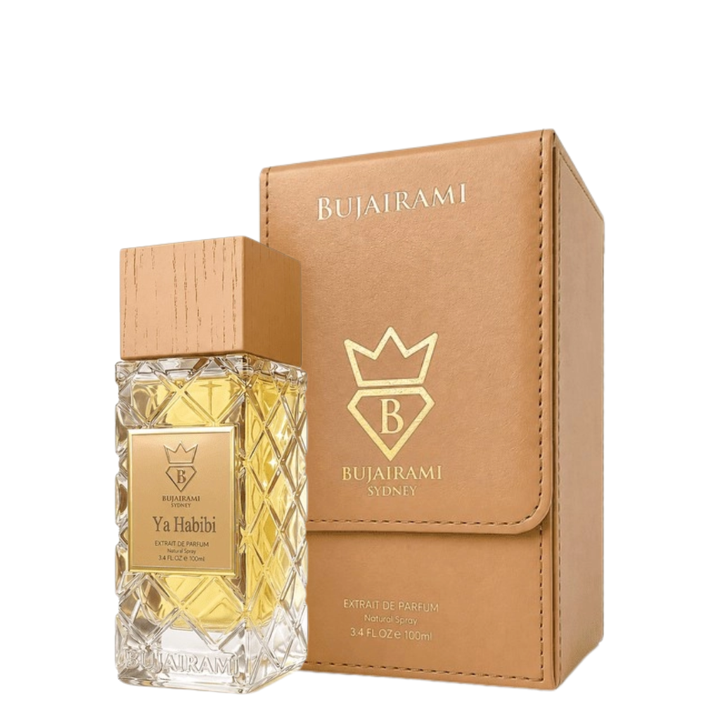 Bujairami Ya Habibi Extrait de Parfum bottle with a wooden cap next to its tan faux-leather box, both featuring gold branding on a white background.