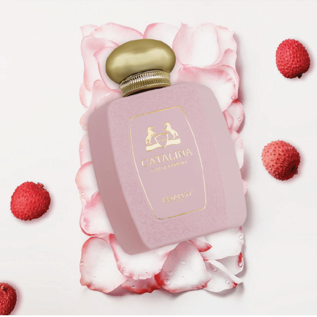 Pink perfume bottle with gold cap on pink petals and raspberries