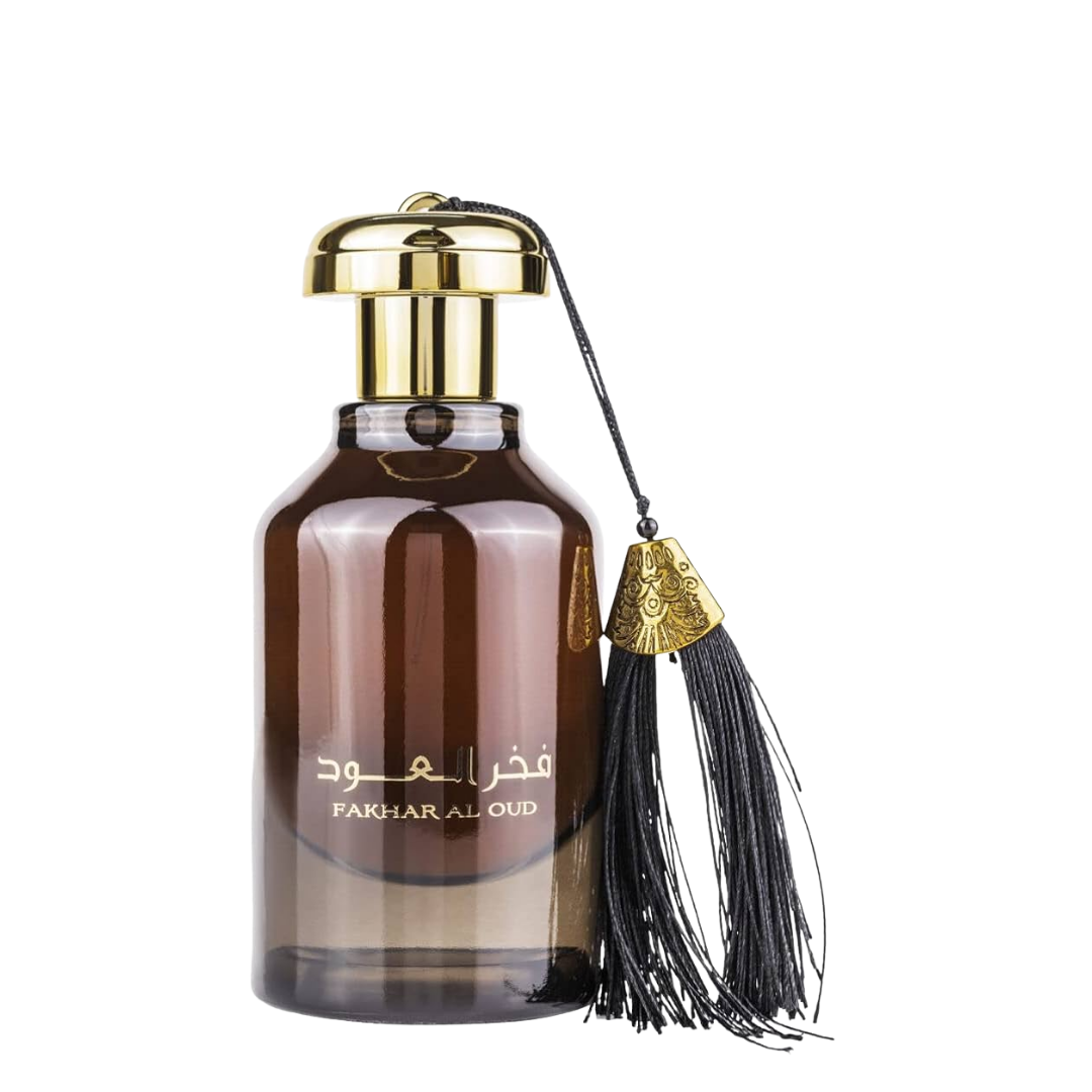 A brown glass bottle of Fakhar Al Oud perfume with a gold-colored cap and a black tassel attached to the bottle.