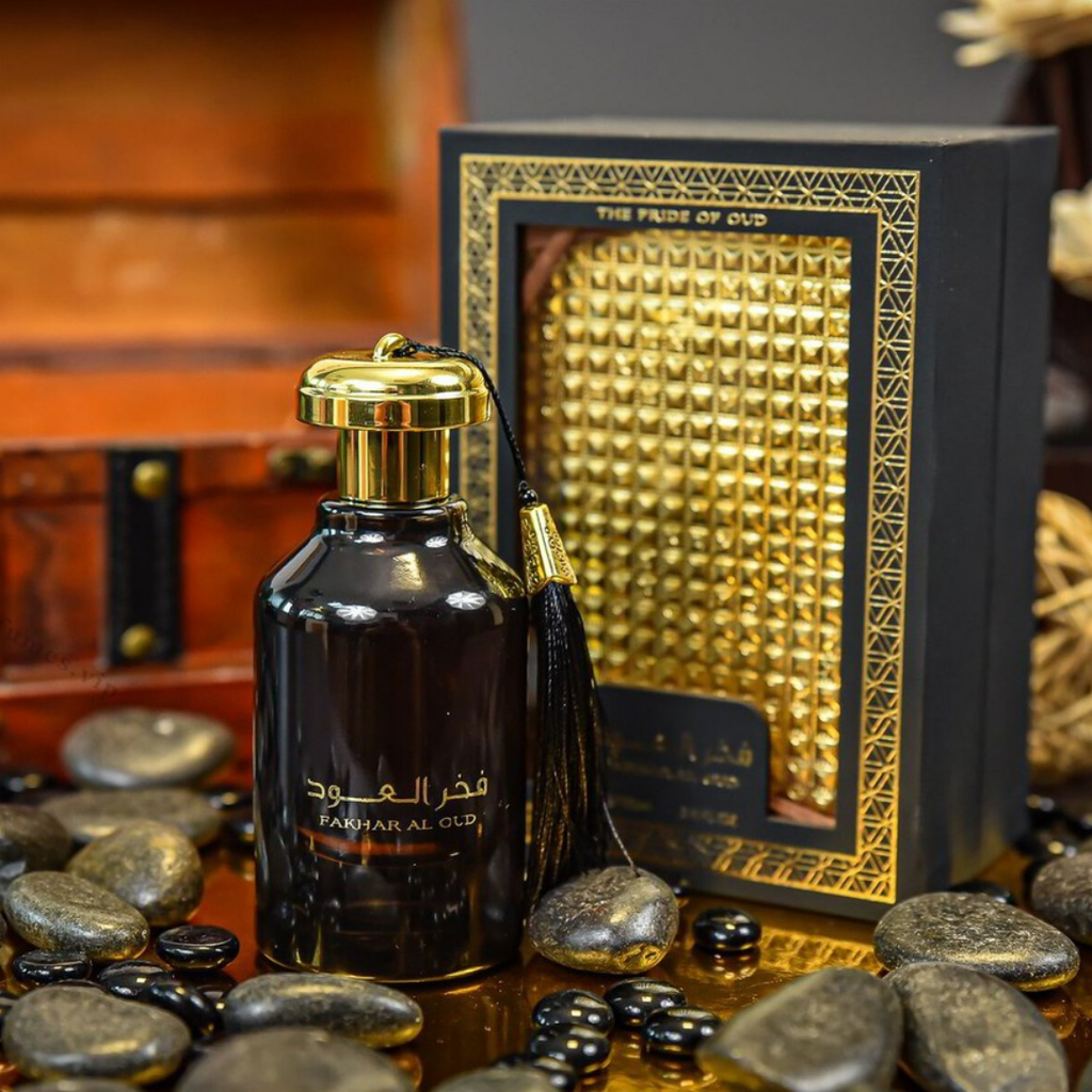Perfume bottle with gold cap and tassel on a textured surface with decorative elements. Fakhar Al Oud by Ard Al Zaafaran Unisex Perfume