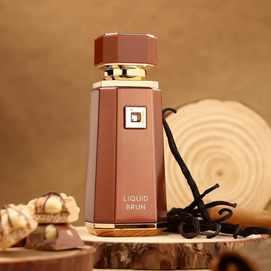 Brown perfume bottle labeled 'LIQUID BRUN' with vanilla beans on a wooden surface.