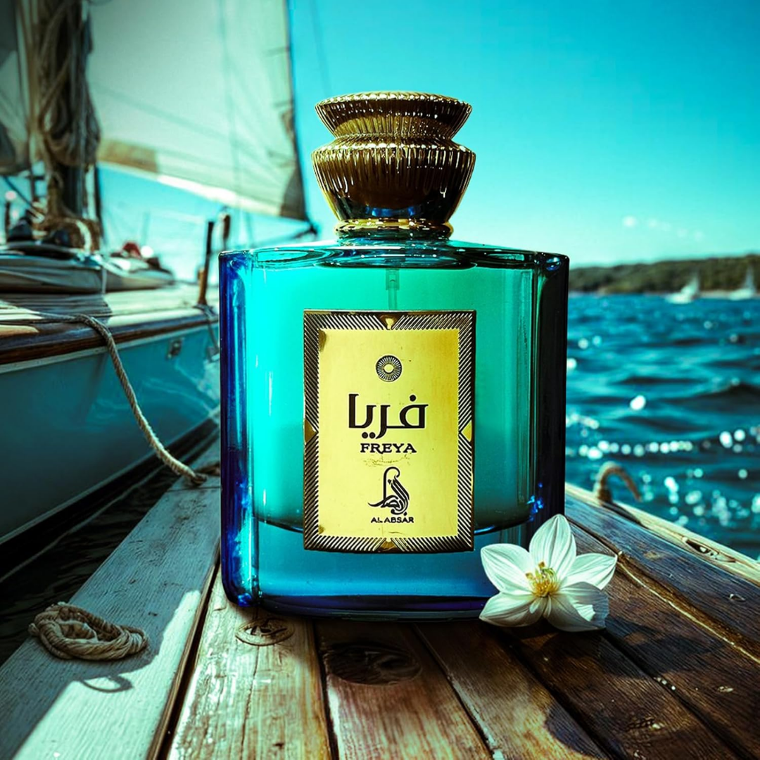 Blue perfume bottle with 'Freya' label on a boat deck with ocean view