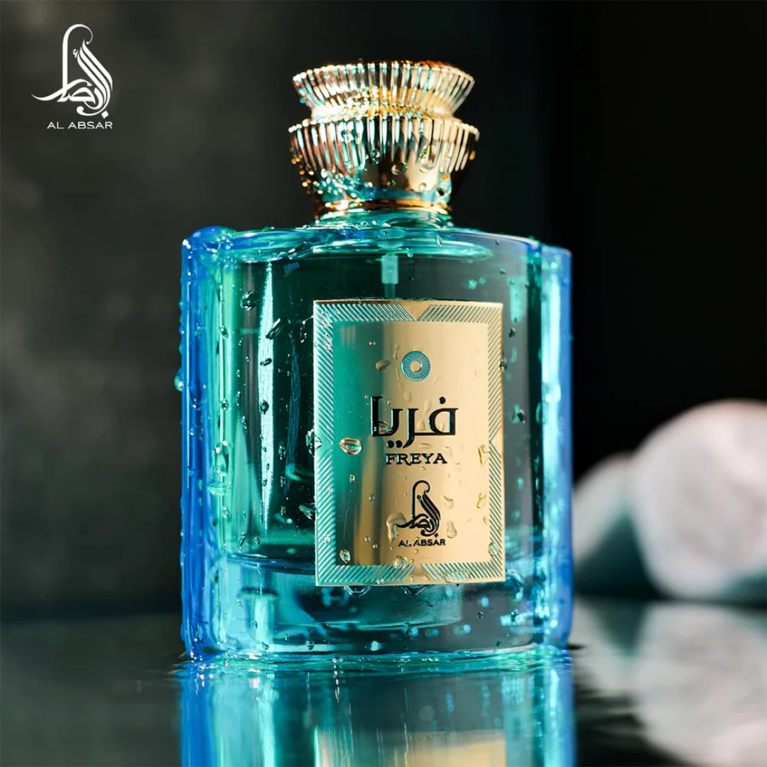 Blue perfume bottle with gold label on a reflective surface, Al Absar brand visible