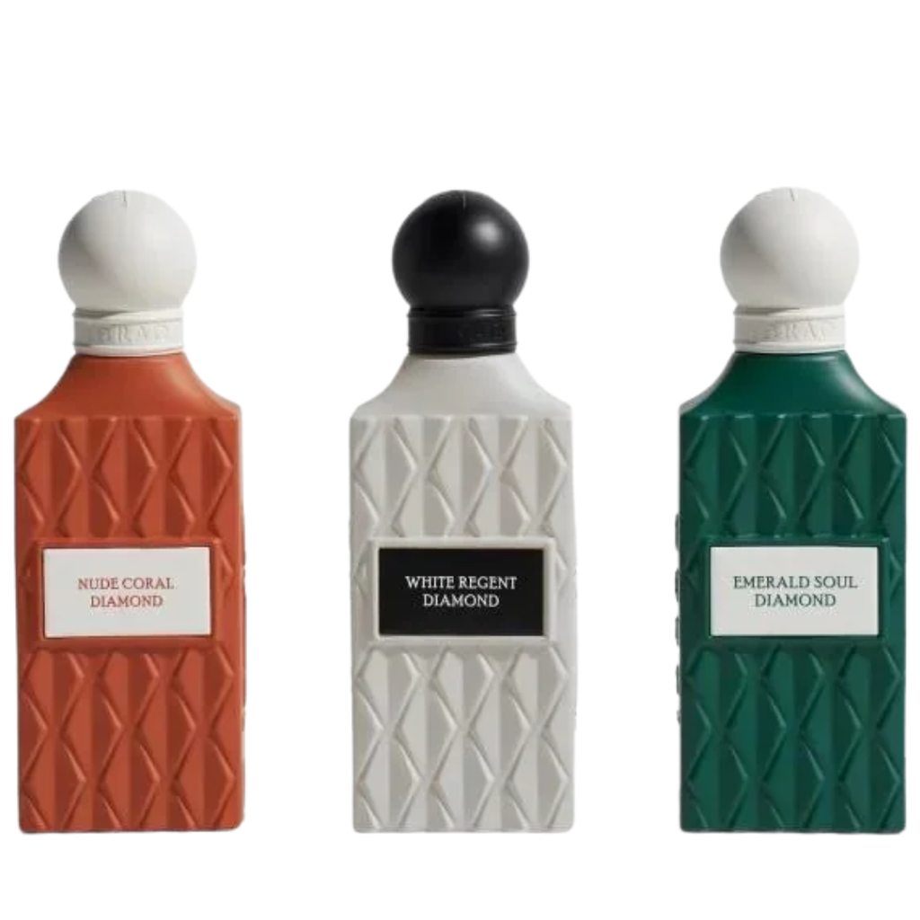 Three perfume bottles with textured geometric designs, labeled Nude Coral Diamond, White Regent Diamond, and Emerald Soul Diamond, shown against a plain white background. IBRAQ: Grey Wish Set