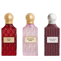 Three perfume bottles from the brand IBRAQ, shown side by side on a white background: Balas Rose in red, Pink Diamond Sakura in light pink, and Purple Heart Diamond in dark purple. Each bottle has a textured diamond pattern, a spherical cap (gold, gold, and white respectively), and a rectangular label with the scent name.