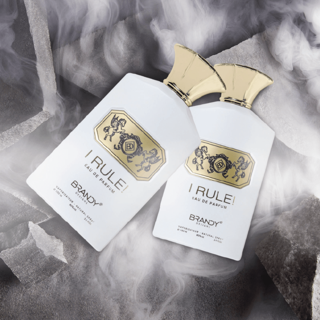 Two bottles of 'I Rule' Brandy perfume with gold accents on a smoky background. I Rule by Brandy Designs Womens Perfume