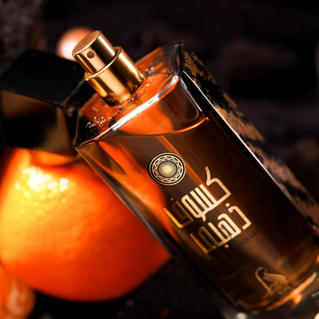 Perfume bottle with gold cap and Arabic text on a dark background. Kasuf Dahabi by Al Absar Womens Perfume