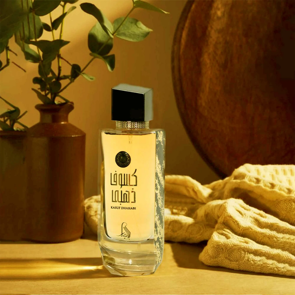 Perfume bottle with decorative elements on a wooden surface. Kasuf Dahabi by Al Absar Womens Perfume
