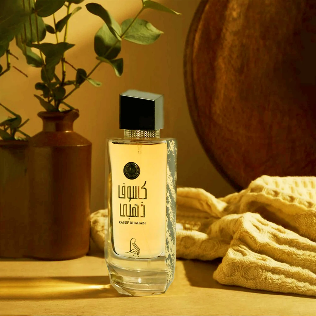 Perfume bottle with decorative elements on a wooden surface. Kasuf Dahabi by Al Absar Womens Perfume