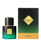 A bottle of INTOXICATE MYSTIQUE La Fede perfume next to its packaging box. The bottle is a dark green to black gradient with a textured diamond pattern and a gold cap.