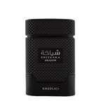 A black textured cylindrical perfume bottle with a textured cap, featuring a black label with white Arabic script and 'SHIYAAKA SHADOW' in English, and 'KHADLAJ+' printed at the bottom, set against a plain white background.
