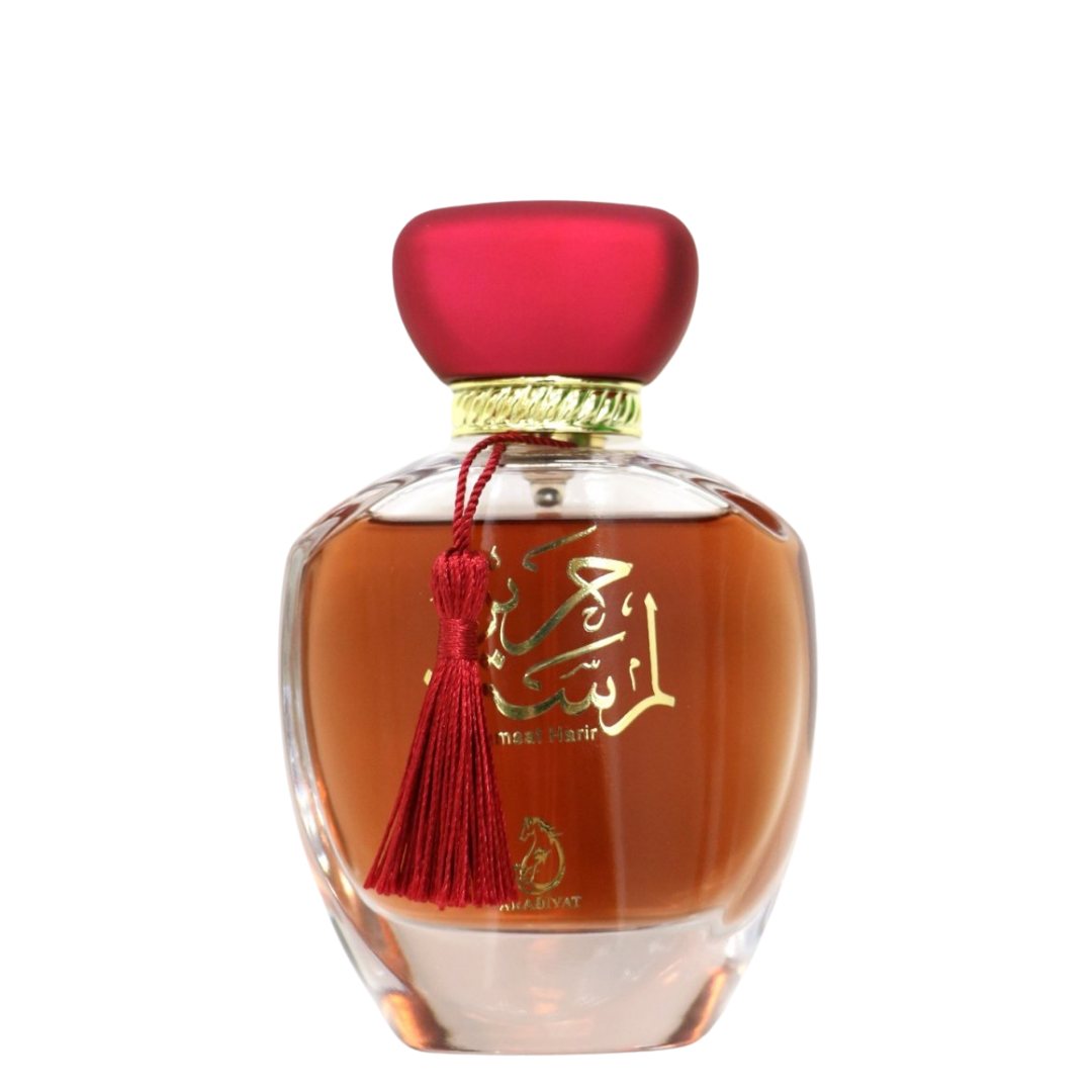 Perfume bottle with red cap and tassel on a white background. Lamsat Harir by Arabiyat Womens Perfume