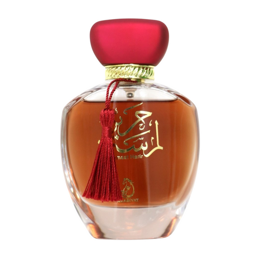 Perfume bottle with red cap and tassel on a white background. Lamsat Harir by Arabiyat Womens Perfume