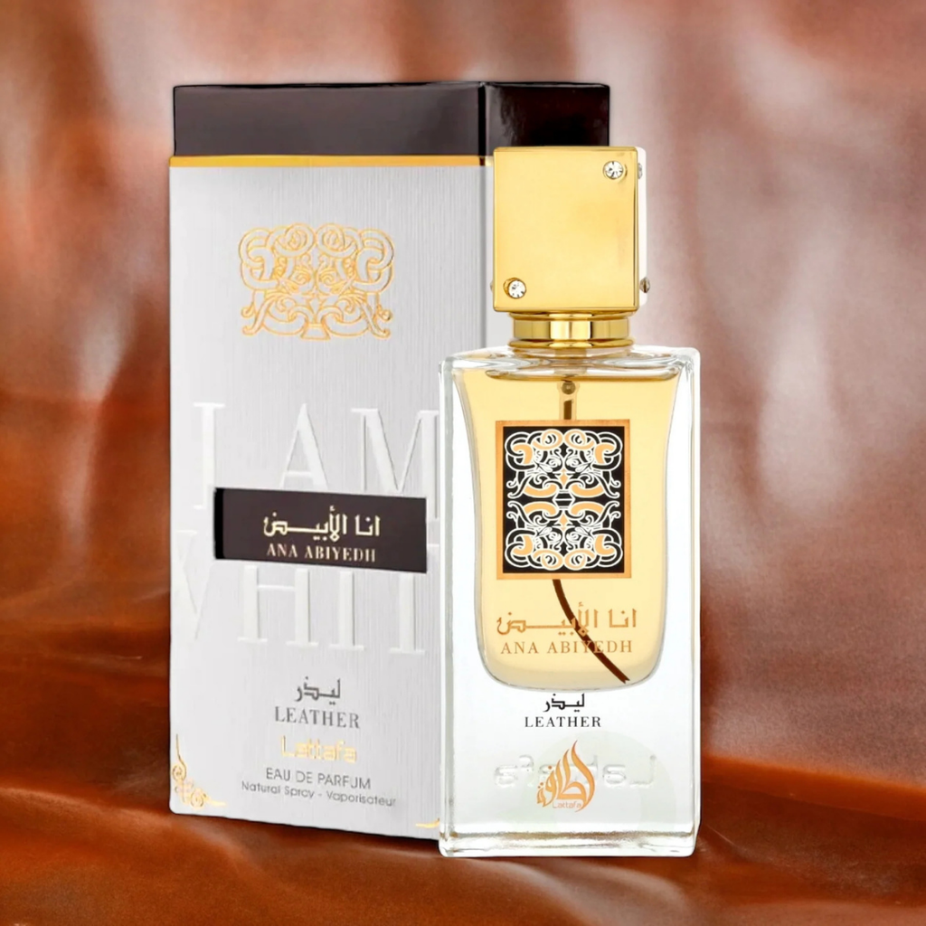 Lattafa Ana Abiyedh Leather perfume display – Stylish product shot with perfume bottle and matching white-gold box against a warm leather-textured background, emphasizing premium and luxurious appeal. 
