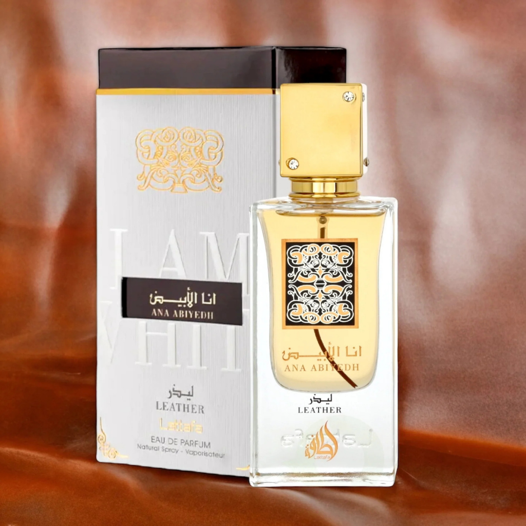 Lattafa Ana Abiyedh Leather perfume display – Stylish product shot with perfume bottle and matching white-gold box against a warm leather-textured background, emphasizing premium and luxurious appeal. Clone / dupe of / inspired by Memo Paris - African Leather perfume.