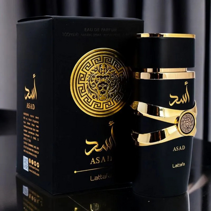 Asad by Lattafa perfume with luxury box – Matte black fragrance bottle with golden details beside matching gold-accented packaging on a reflective black surface. Clone / dupe of / inspired by Dior - Sauvage Elixir perfume.