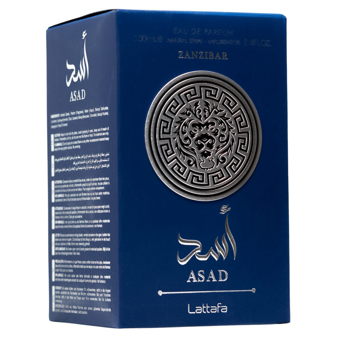 Lattafa Asad Zanzibar fragrance box in royal blue with embossed silver lion emblem and Arabic text. Clone / dupe of / inspired by Jean Paul Gaultier - Le Beau perfume.