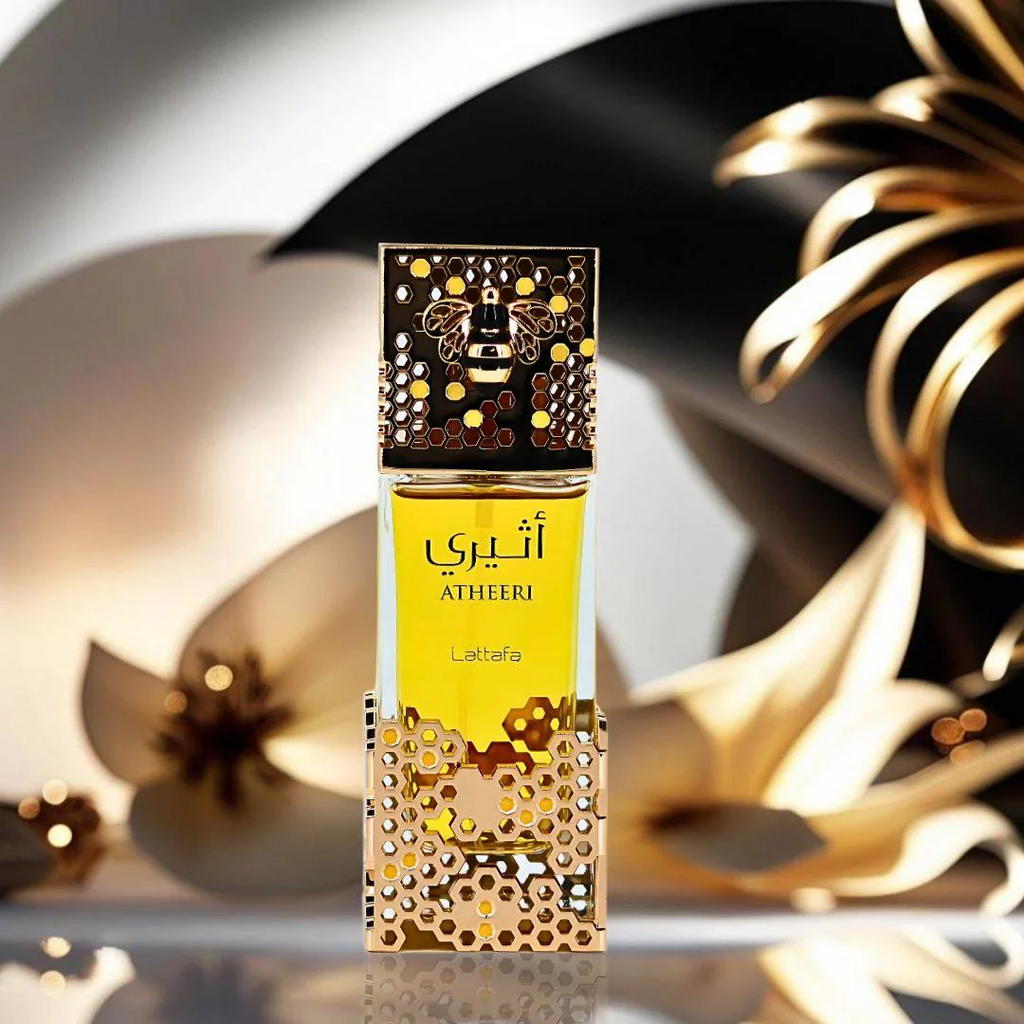Perfume bottle with gold and black design on a reflective surface. Lattafa Atheeri Womens Perfume