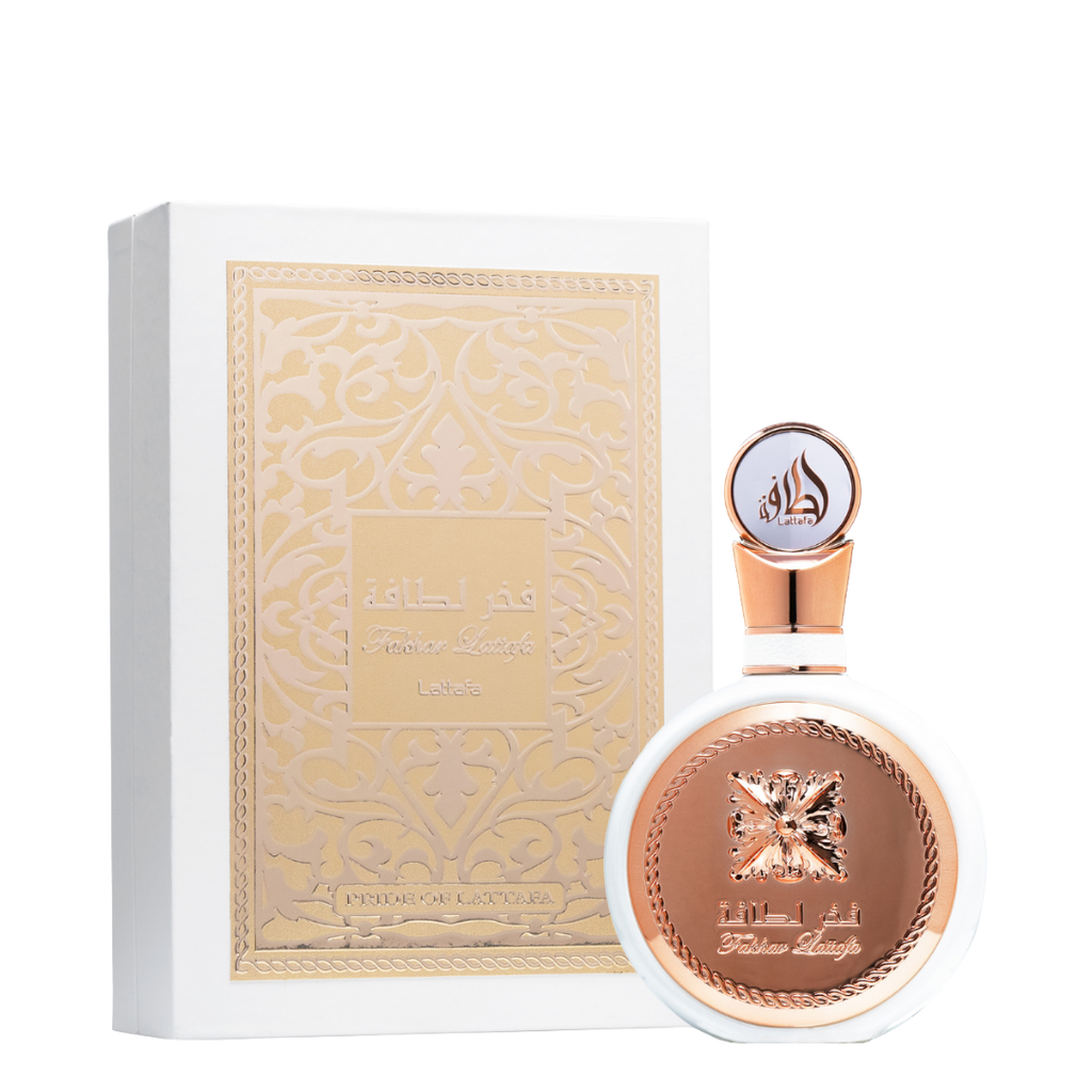 A bottle of Fakhar Rose perfume from Lattafa, with a rose gold cap and label featuring an intricate design.  Lattafa Fakhar Eau de Parfum in luxurious white and gold packaging, showcasing intricate embossed Arabic design and round bottle with rose-gold detailing.